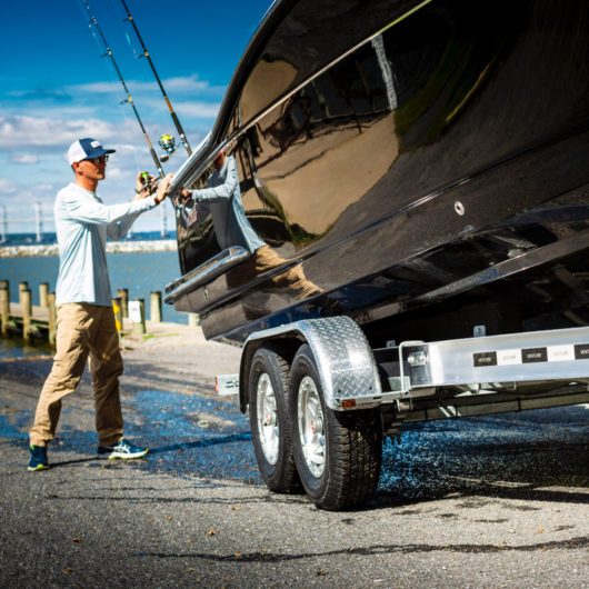 man loading a boat onto a venture trailer